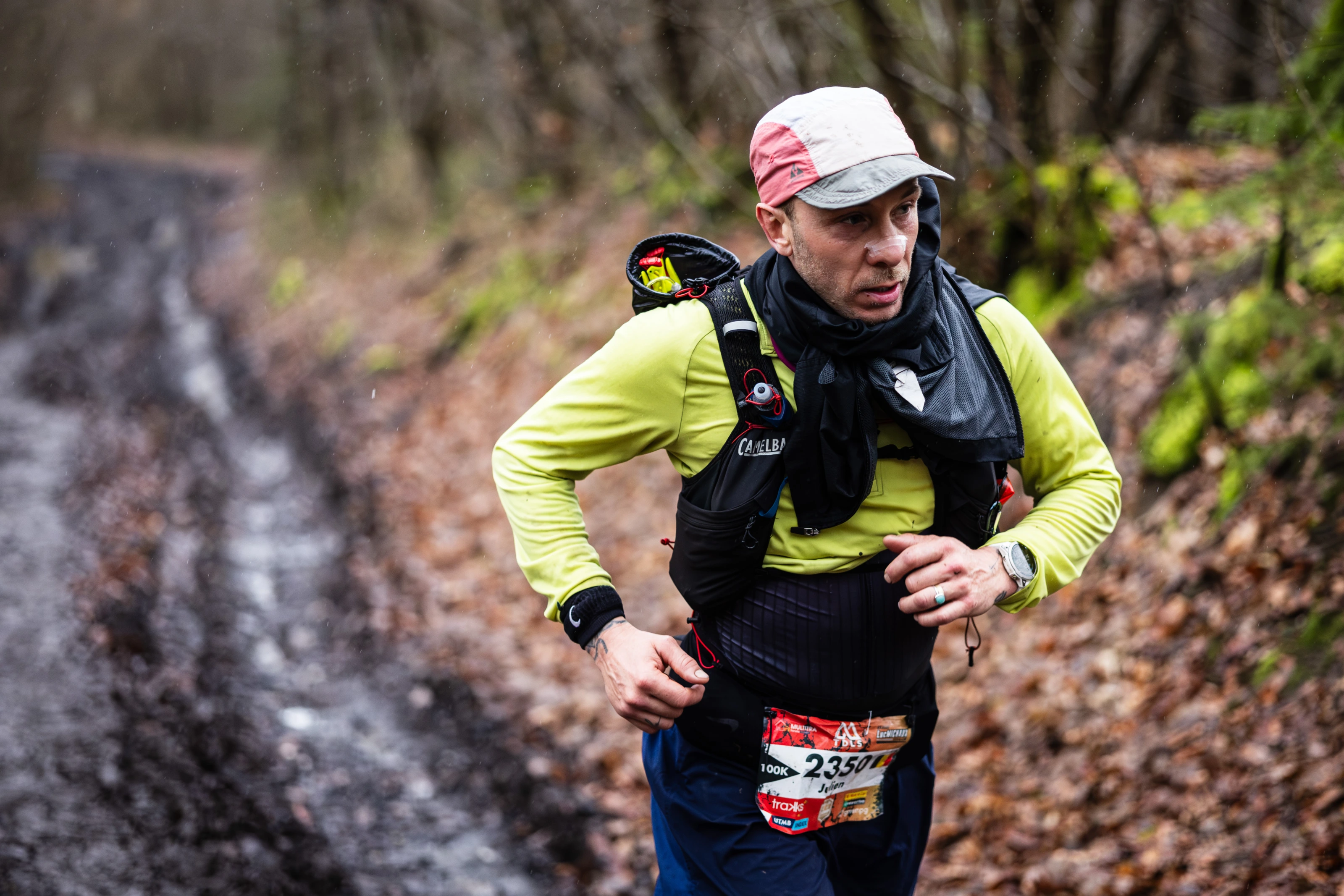 Un coureur du Trail de la Sibérie descend un sentier rocheux en forêt.